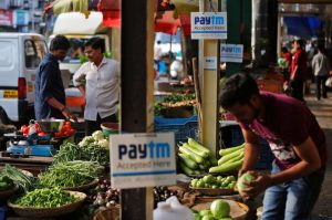 Advertisement boards of Paytm, a digital wallet company, are seen placed at stalls of roadside vegetable vendors as they wait for customers in Mumbai, India, November 19, 2016. REUTERS/Shailesh Andrade